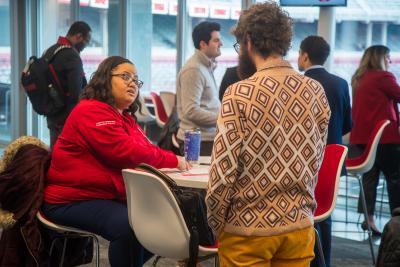 A career coach working with a student at a networking event.