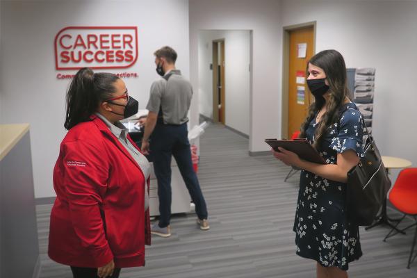 A student and a Career Coach interact in the reception area of the Center for Career and Professional Success