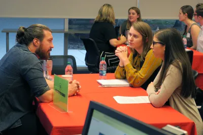 Two students talk with an alumni at a Life Beyond Degree event