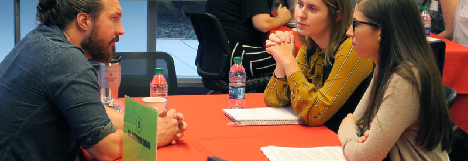 Two students talk with an alumni at a Life Beyond Degree event